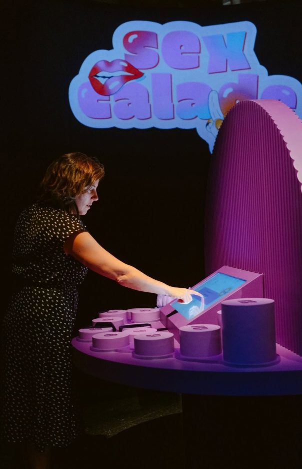 Visiteuse jouant à Sexcalade sous le logo projeté du jeu. Photo : Musée de la civilisation