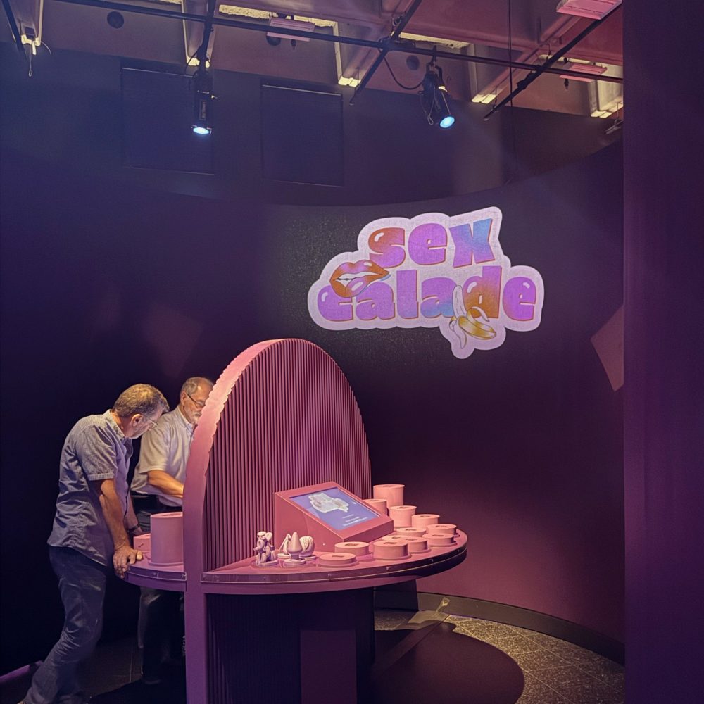 Visiteurs jouant à Sexcalade sous le logo projeté du jeu
